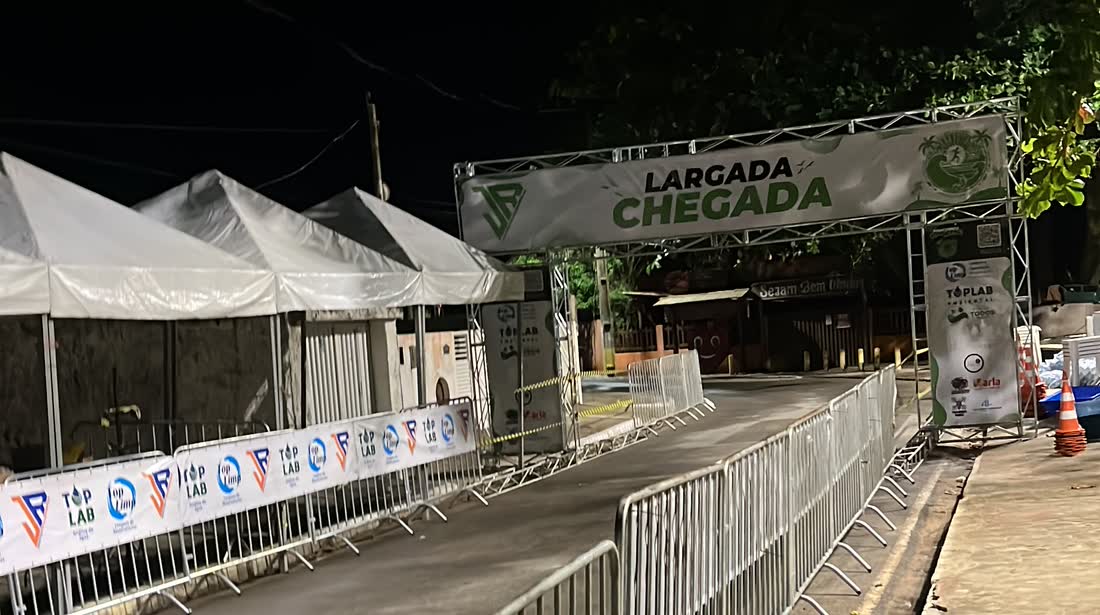 Estrutura de largada e chegada da JR montada na rua, com pórtico, gradis e tendas